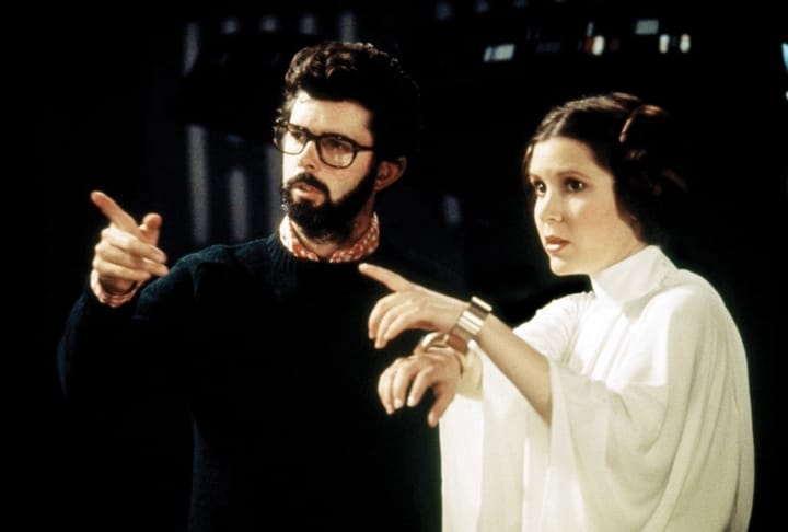 George Lucas and Carrie Fisher make a cameo as a kissing couple in what 1990s fantasy film?